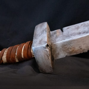 Prop straight sword hilt, based on Dark Souls, propped up at a 45-degree angle on a black background