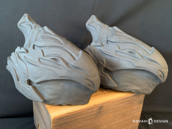 Two raw resin casts of the Helm of Artorias. Posed on a wooden crate, facing right.