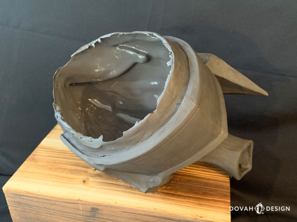 Single resin cast of the Helm of Artorias, unfinished straight out of the mold. Posed on a wooden crate with the open bottom facing up and raw edges visible.