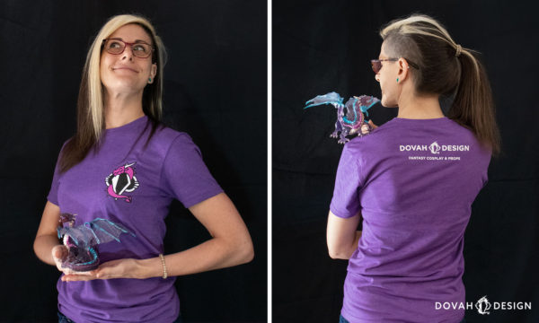 Sam wearing the dovah design t-shirt in extra small, showing both front and back views, holding a toy purple dragon, on a black background.