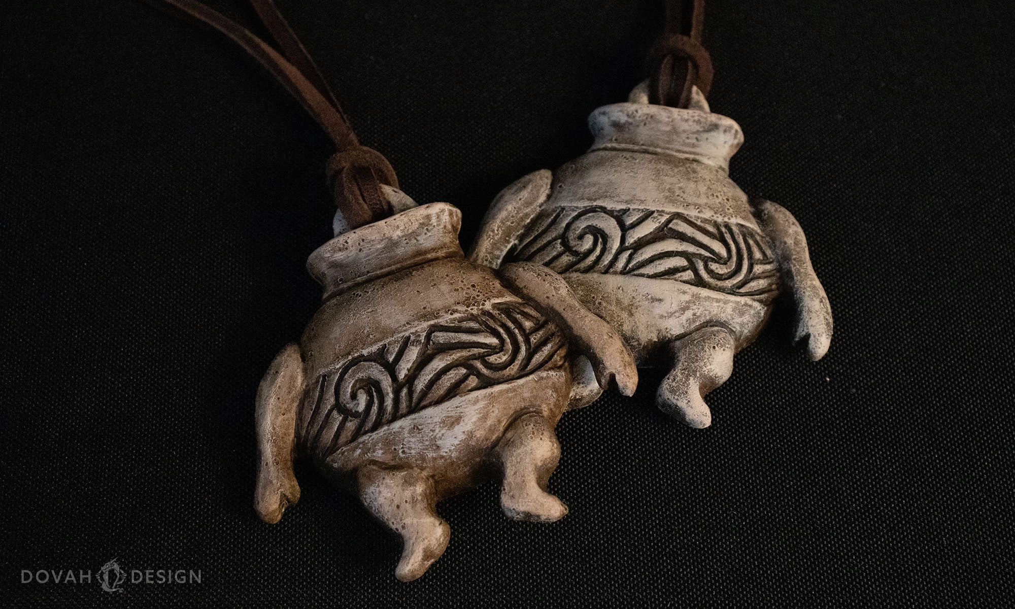 Detail view of two companion jar talismans, sitting on a black tablecloth.