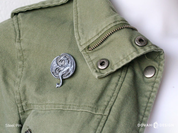 Elsweyr dragon logo lapel pin, pinned on a green cotton jacket for scale.