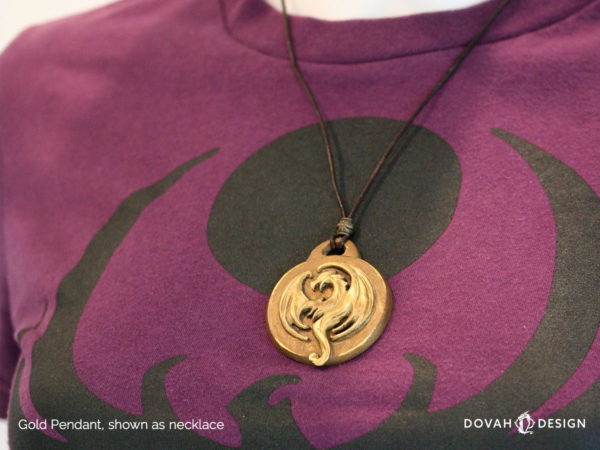 Elder Scrolls Online Elsweyr logo, gold resin cast pendant necklace. Shown as a necklace on display mannequin. Logo depecits a drake symbol on leather tie with hook and bar closure.
