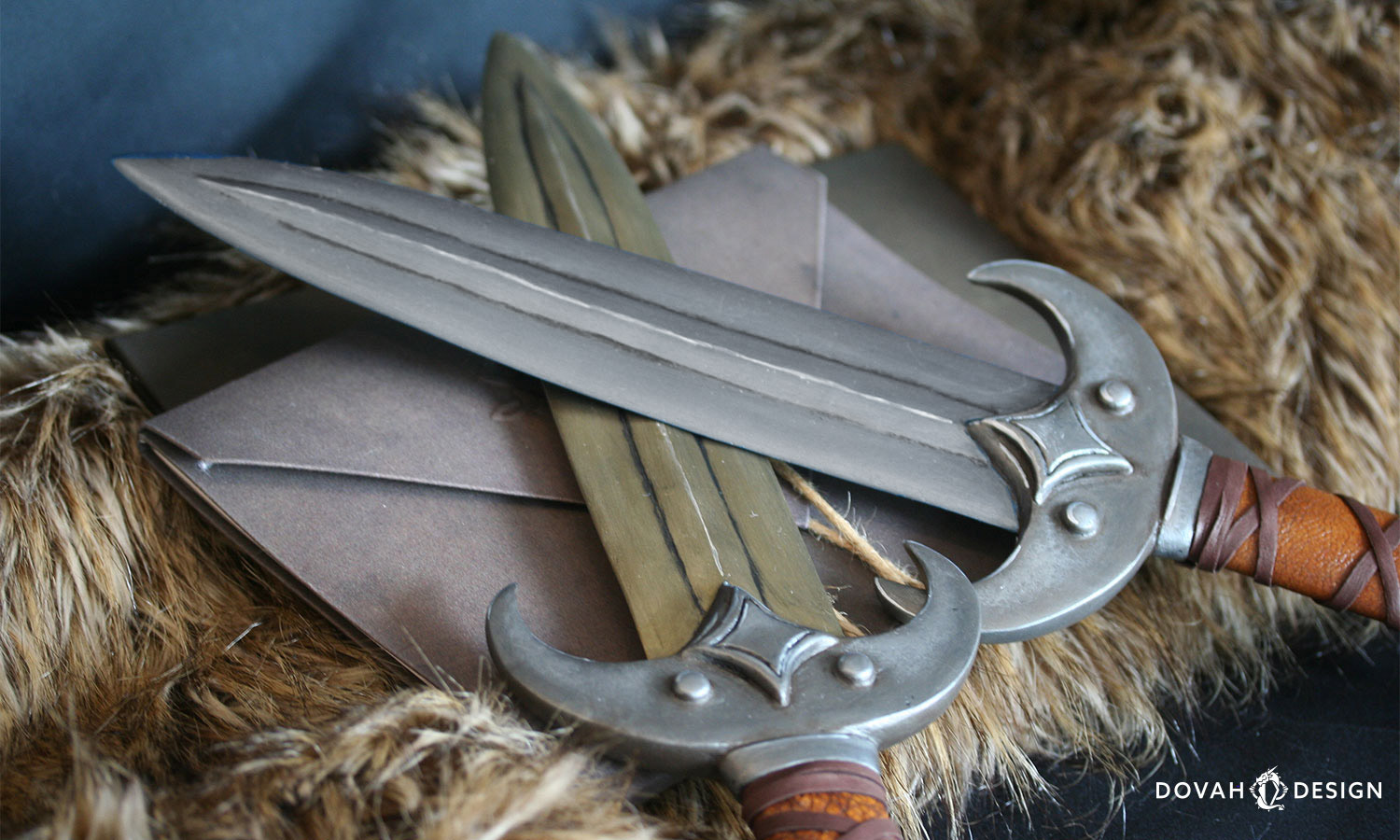 Iron khajiit style prop dagger posed over a gold Calcinium khajiit dagger, both crossed and posed stylistically overtop a stack of old-looking papers and brown fur.