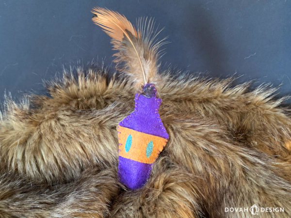 Single skooma cat toy shown posed on a fur blanket with black background.