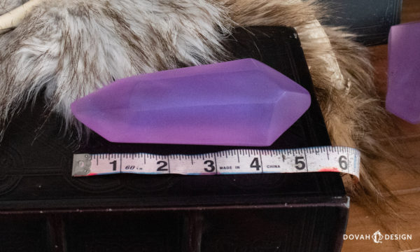 A single lesser soul gem replica, resting on a box with fur in the background, next to a tape measure showing the length of the prop is approximately 5.25 inches.