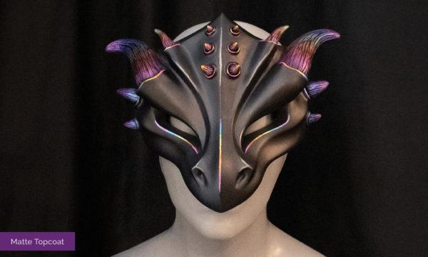Rainbow dragon mask with matte finish, facing foreward, tied on mannequin bust, in front of a black backdrop.