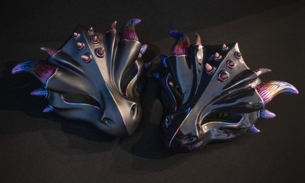 Glossy and Matte "Rainbow Horned" masquerade style dragon masks, shown side by side sitting on table with black background