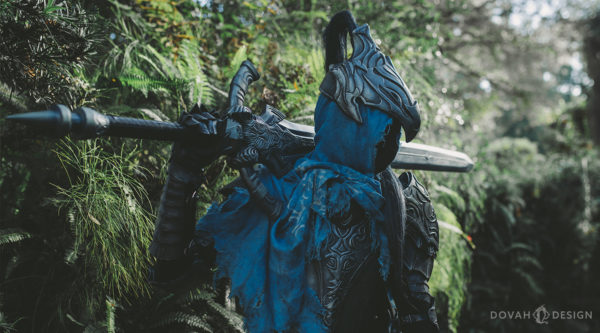 Knight Artorias posing with his greatsword over his right shoulder, facing right.