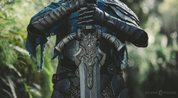 Prop Greatsword of Artorias, held vertically with two hands by Sam in her Artorias cosplay.