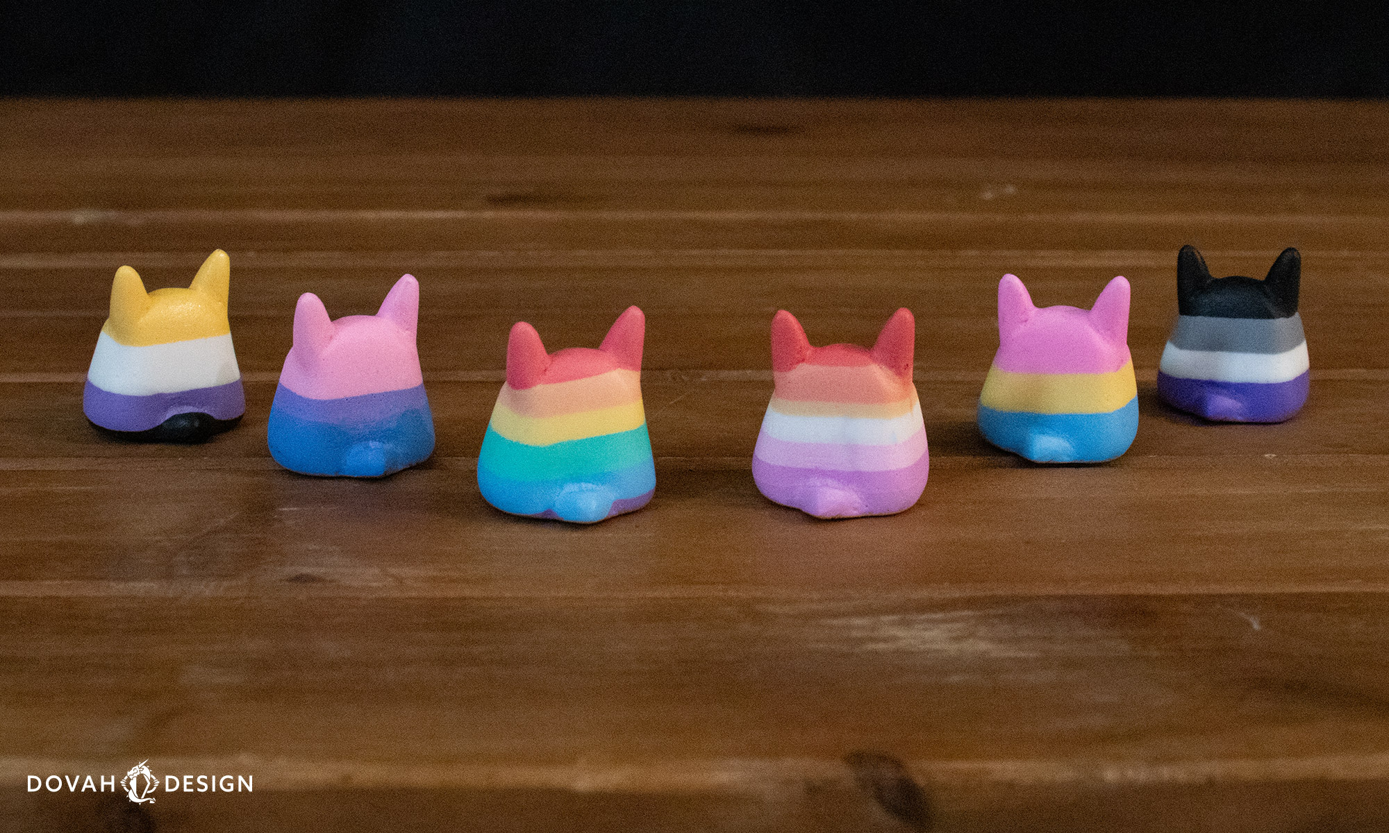 Set of six Totoro bunnies in pride colors, facing backward, with small bunny tails showing.